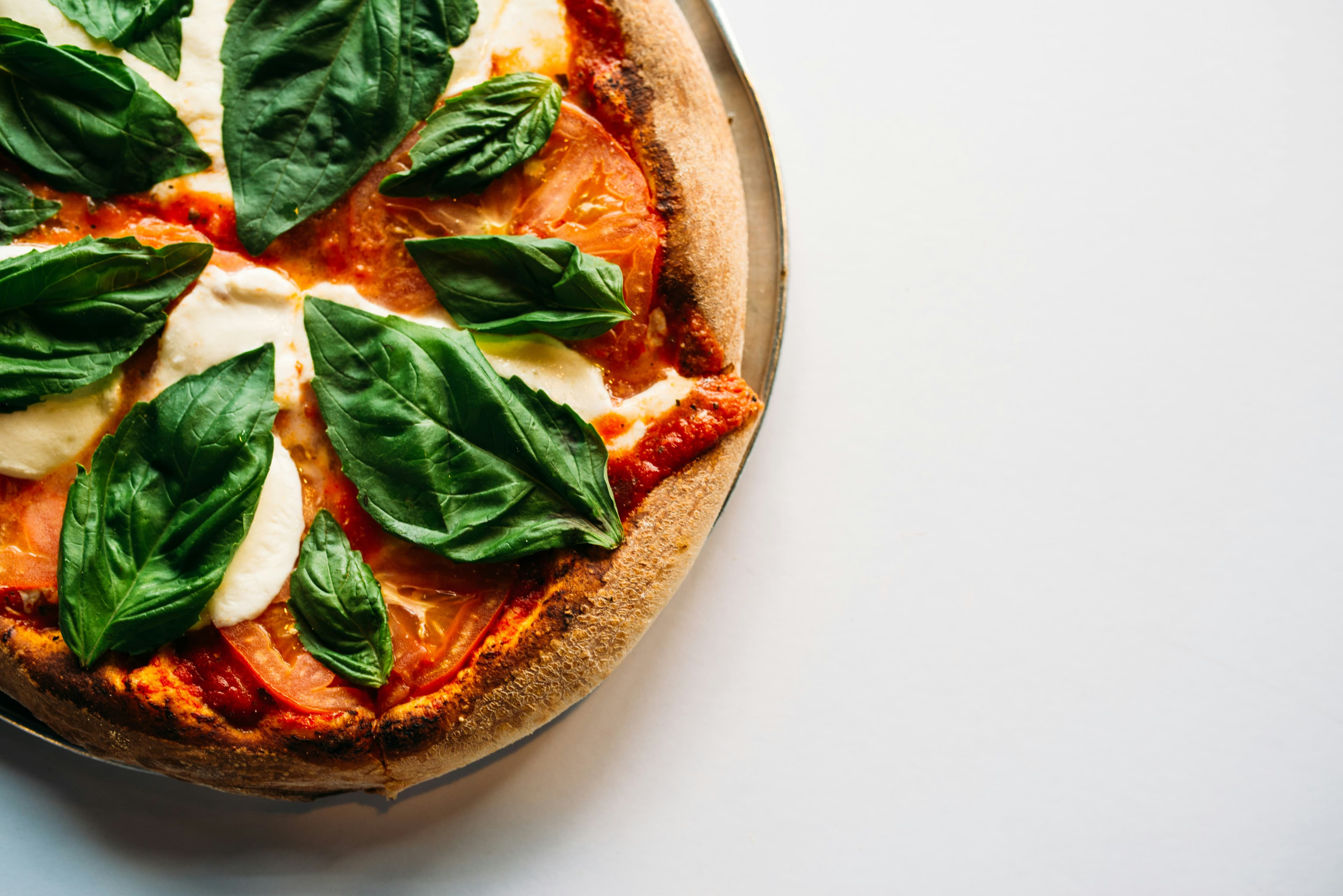 Tomato pizza with fresh tomato slices, basil leaves and oregano